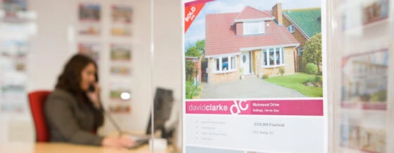 David Clarke Estate Agent in Herne Bay office with a 'SOLD' property advert featuring a house in Richmond Drive, Beltinge.